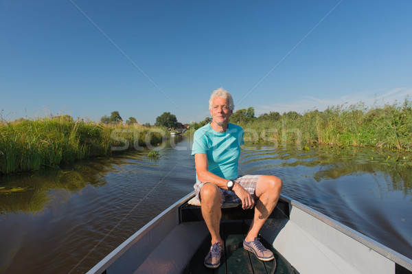 Senior man in motor boat Stock photo © ivonnewierink