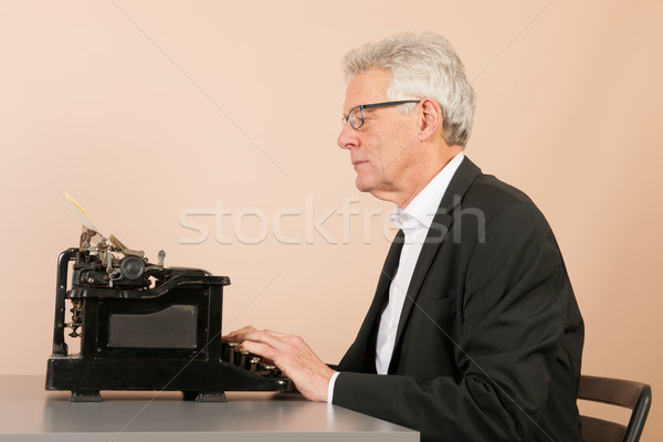 Senior man with antique typewriter Stock photo © ivonnewierink