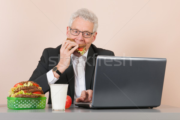 Senior man with lunch box at the office Stock photo © ivonnewierink