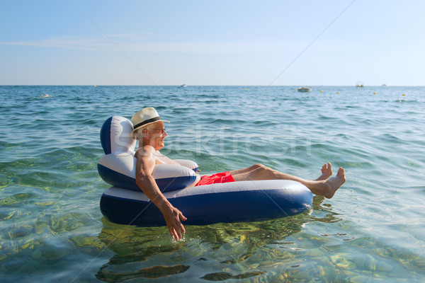 Stock photo: Senior man floating in sea