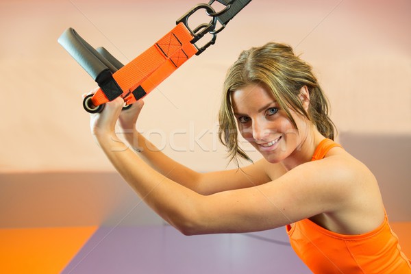 Young woman doing suspension training Stock photo © ivonnewierink