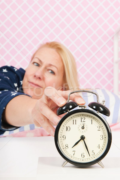 Woman put out the alarm clock Stock photo © ivonnewierink