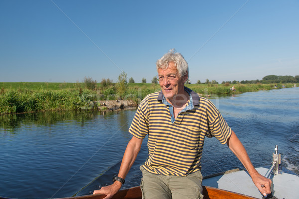 Senior man in boat on river Stock photo © ivonnewierink