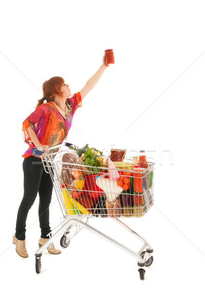 Woman with Shopping cart picking food from high cupboard Stock photo © ivonnewierink