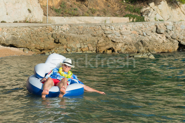 Senior man floating in sea Stock photo © ivonnewierink