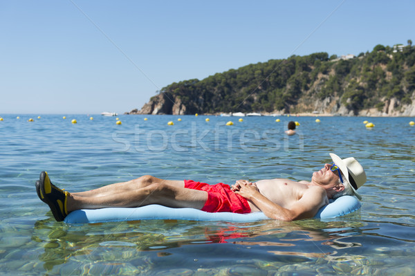 Nyugdíjas férfi alszik ágy tenger víz Stock fotó © ivonnewierink