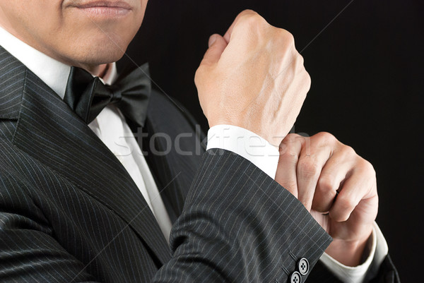 Stock photo: Man In Tux Fixes Cufflink