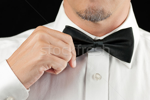 Man In Tux Straightens Bowtie, One Hand Stock photo © jackethead