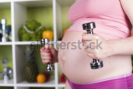 Attractive pregnant woman using a dumbbell while training Stock photo © JanPietruszka