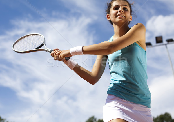 Stock photo: Young woman tennis player on the court 