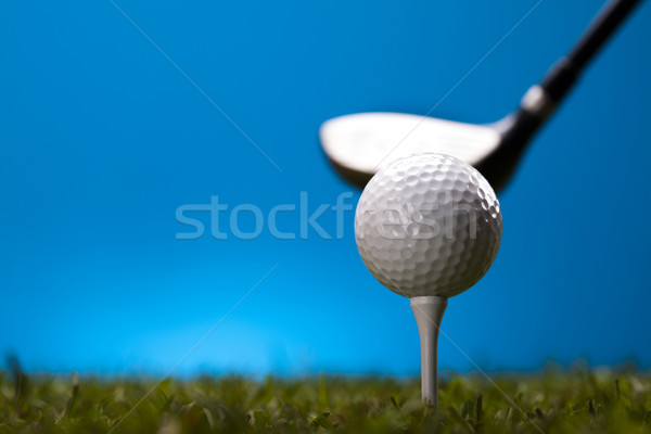 Golf ball on green grass over a blue background  Stock photo © JanPietruszka