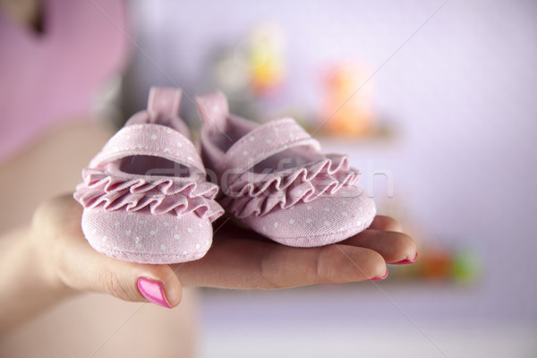 Pregnant woman holding a pair of tiny shoes Stock photo © JanPietruszka