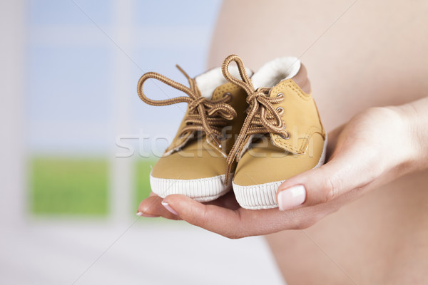 Pregnant woman holding baby shoes in her hands Stock photo © JanPietruszka