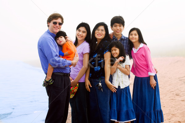 Multiracial family of seven on foggy beach Stock photo © jarenwicklund
