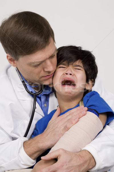 Male doctor comforting scared  toddler patient. Child is disabled with cerebral palsy. Stock photo © jarenwicklund