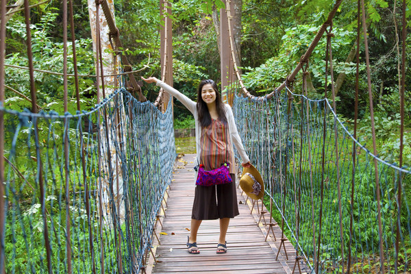 Teen girl on wooden hanging bridge in woods Stock photo © jarenwicklund