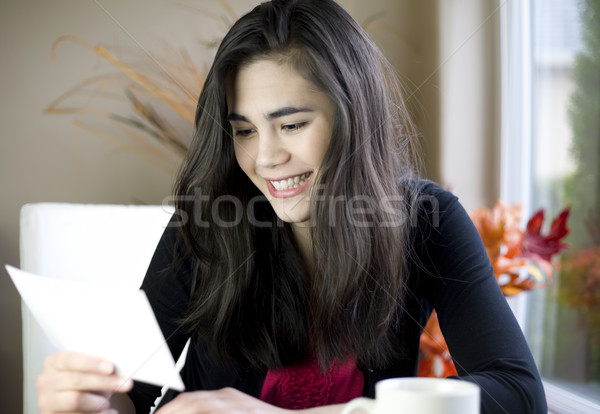 Teenage girl or young woman happily reading note in hand Stock photo © jarenwicklund