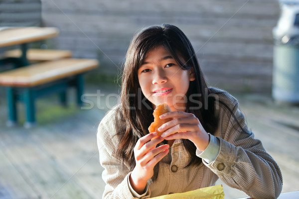 Young biracial teen girl outdoors eating hamburger Stock photo © jarenwicklund
