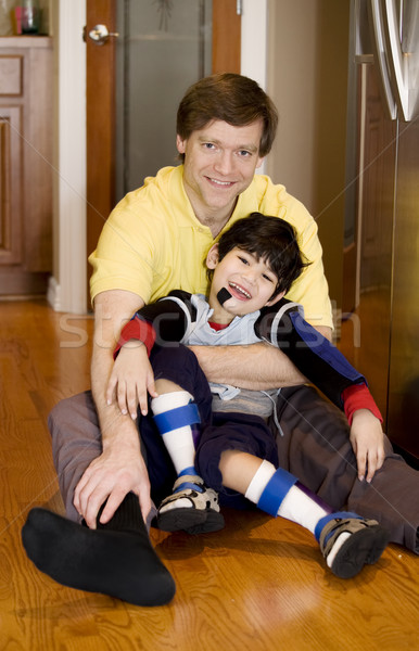 Father holding disabled son on kitchen floor Stock photo © jarenwicklund