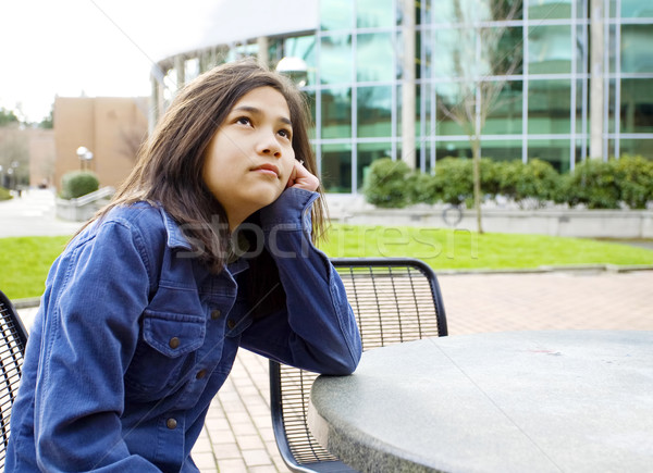 Stock photo: Preteen girl sitting outdoors looking up at sky