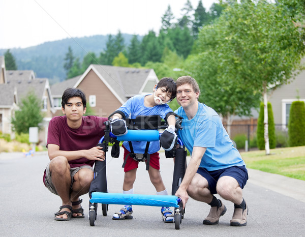 Disabled boy in walker surrounded by father and older brother Stock photo © jarenwicklund