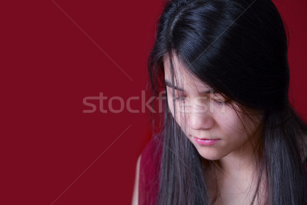 Beautiful, biracial teen girl looking down, depressed or sad, on Stock photo © jarenwicklund