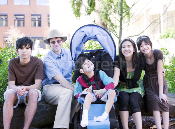 Father sitting with his biracial children and disabled son Stock photo © jarenwicklund