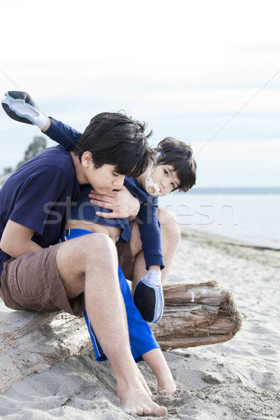 Big brother holding disabled boy on beach Stock photo © jarenwicklund