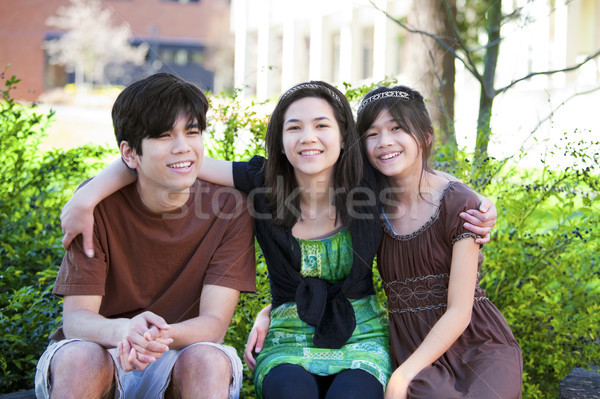 Tre fratello sorelle seduta esterna sorridere Foto d'archivio © jarenwicklund