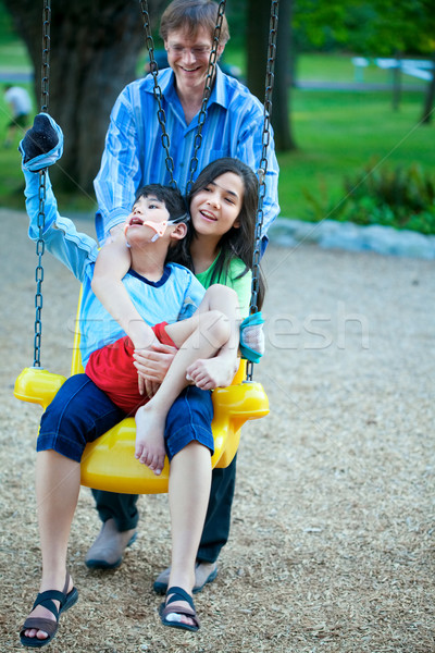 Big sister holding disabled brother on special needs swing at pl Stock photo © jarenwicklund