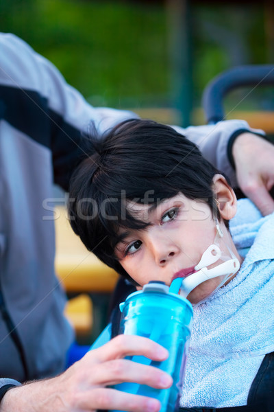 Disabled biracial little boy in wheelchair drinking water from s Stock photo © jarenwicklund