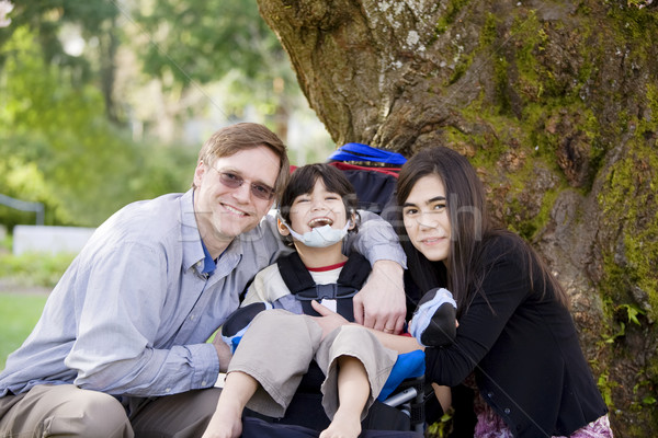 Disabled boy in wheelcahir surrounded by father and sister Stock photo © jarenwicklund