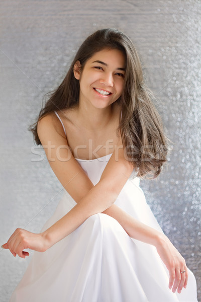 Beautiful biracial teen girl in white dress, sitting arms crosse Stock photo © jarenwicklund