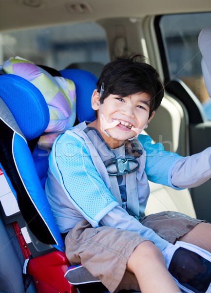 Handsome disabled six year old boy smiling in carseat Stock photo © jarenwicklund
