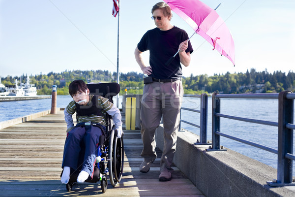 Father walking with disabled son out on lake pier Stock photo © jarenwicklund