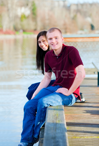 Beautiful interracial couple sitting on wooden dock over lake Stock photo © jarenwicklund