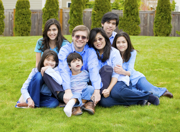 Large family of seven sitting together on lawn, dressed in blue  Stock photo © jarenwicklund