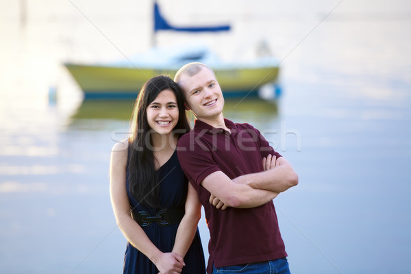 Happy young interracial couple standing together by lake Stock photo © jarenwicklund