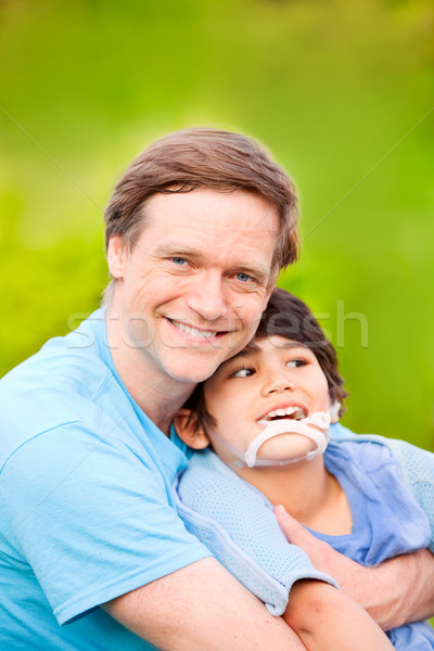 Handsome father holding smiling disabled son outdoors Stock photo © jarenwicklund