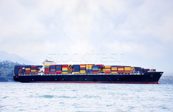 Stock photo: Large cargo ship in water carrying colorful shipping containers