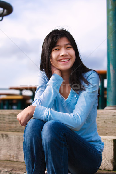 Young teen girl sitting on wooden steps outdoors on overcast clo Stock photo © jarenwicklund
