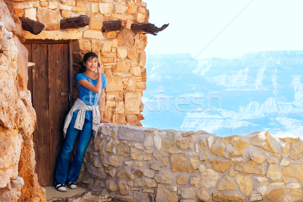 Biracial teen girl relaxing, leaning against rock wall overlooki Stock photo © jarenwicklund