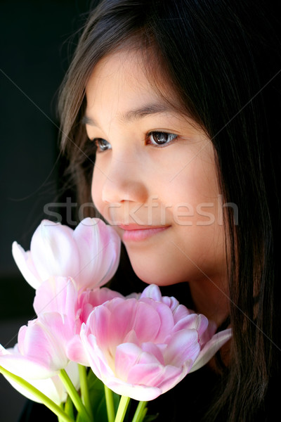 Beautiful little girl with pink tulips by face Stock photo © jarenwicklund
