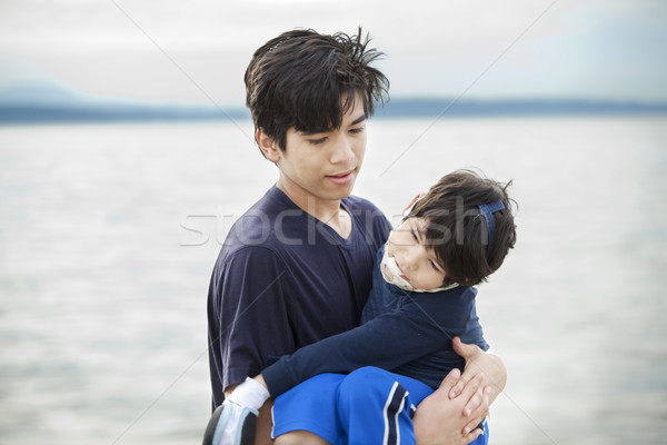 Big brother carrying disabled boy by lake shore Stock photo © jarenwicklund