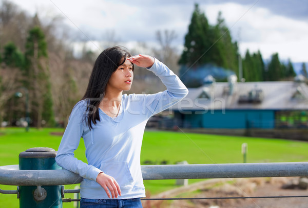 Young teen girl standing, leaning against railing at park shadin Stock photo © jarenwicklund