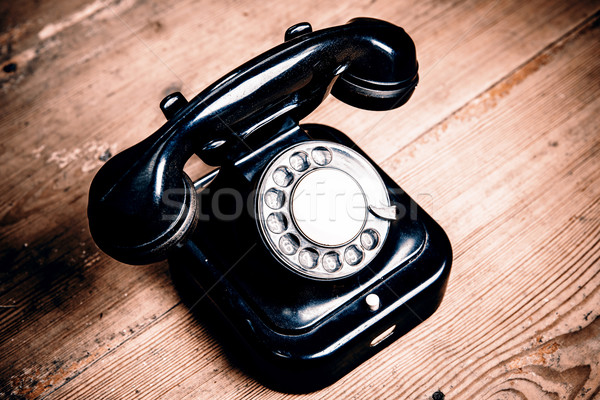 Old black phone with dust and scratches on wooden floor Stock photo © jarin13