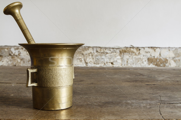 Stock photo: Old bronze mortar with pestle on wootden table
