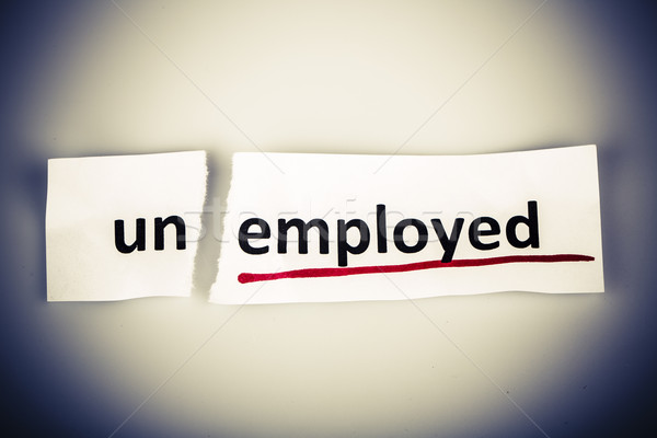 The word unemployed changed to employed on torn paper Stock photo © jarin13