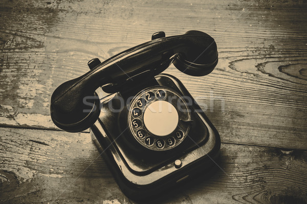 Old black phone with dust and scratches on wooden floor Stock photo © jarin13