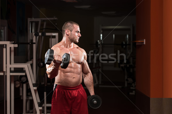 Bodybuilder Exercising Biceps With Dumbbells Stock photo © Jasminko